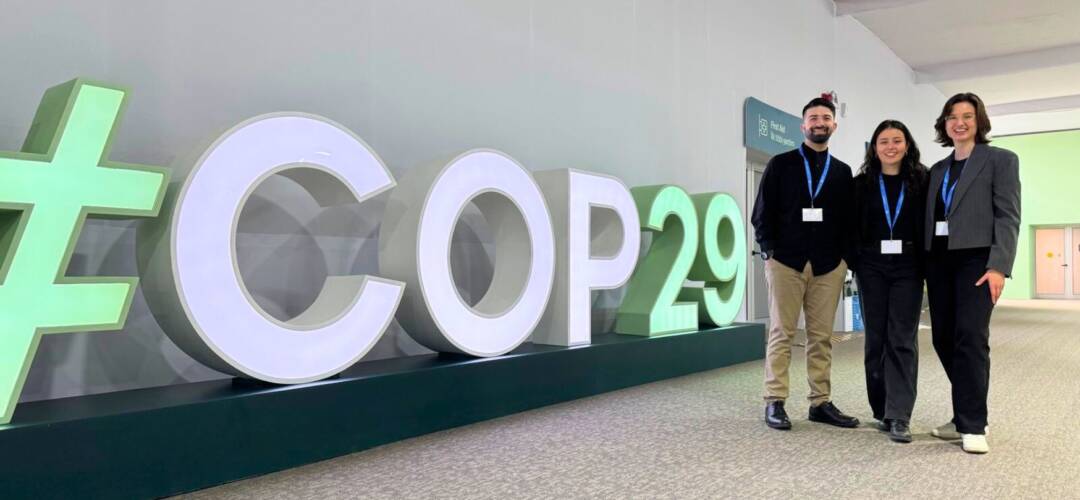 Personen vor COP29-Schild