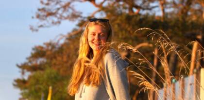 Lächelnde Frau in der Natur bei Sonnenuntergang