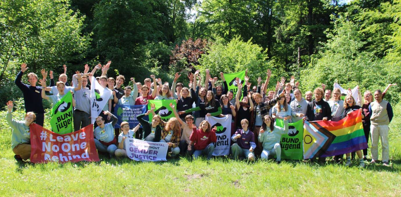 Gruppe von Menschen mit Bannern in der Natur.