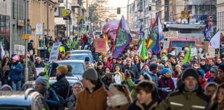 Protestierende Menschen mit Plakaten in einer Stadt.
