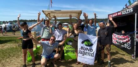 Gruppe feiert mit BUNDjugend-Banner im Freien.