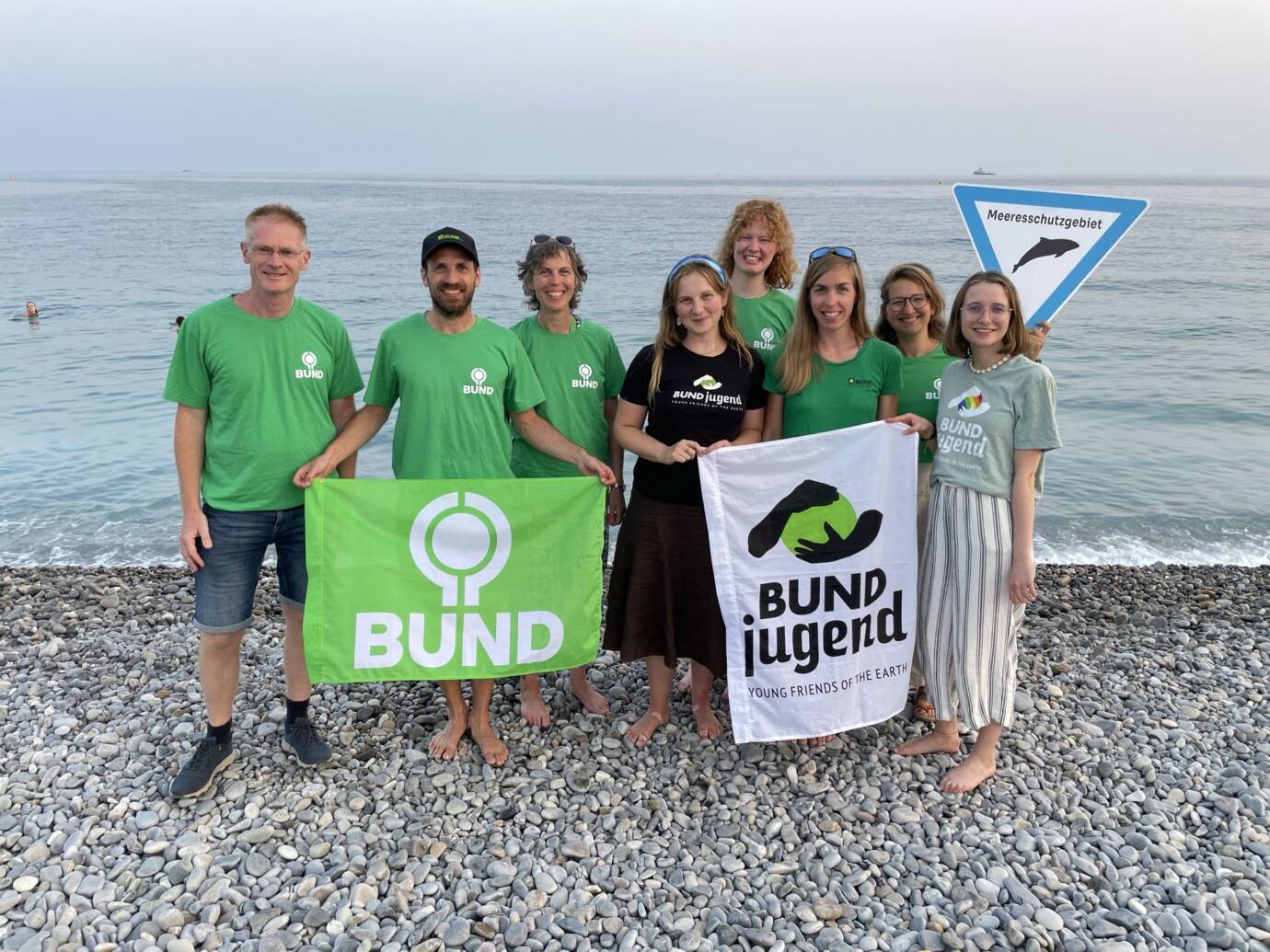 Menschen am Strand mit BUND-Banner