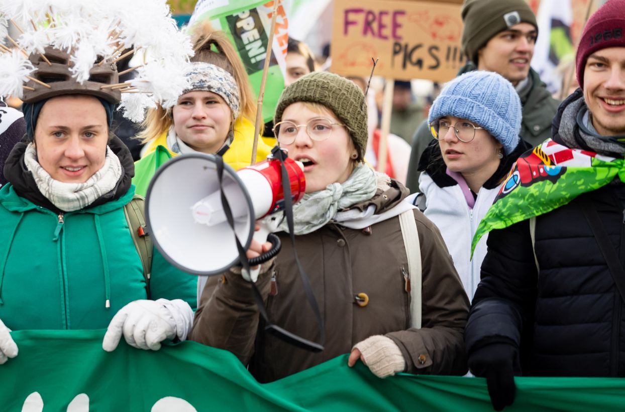 Demonstranten mit Megafon bei Protestkundgebung im Freien.