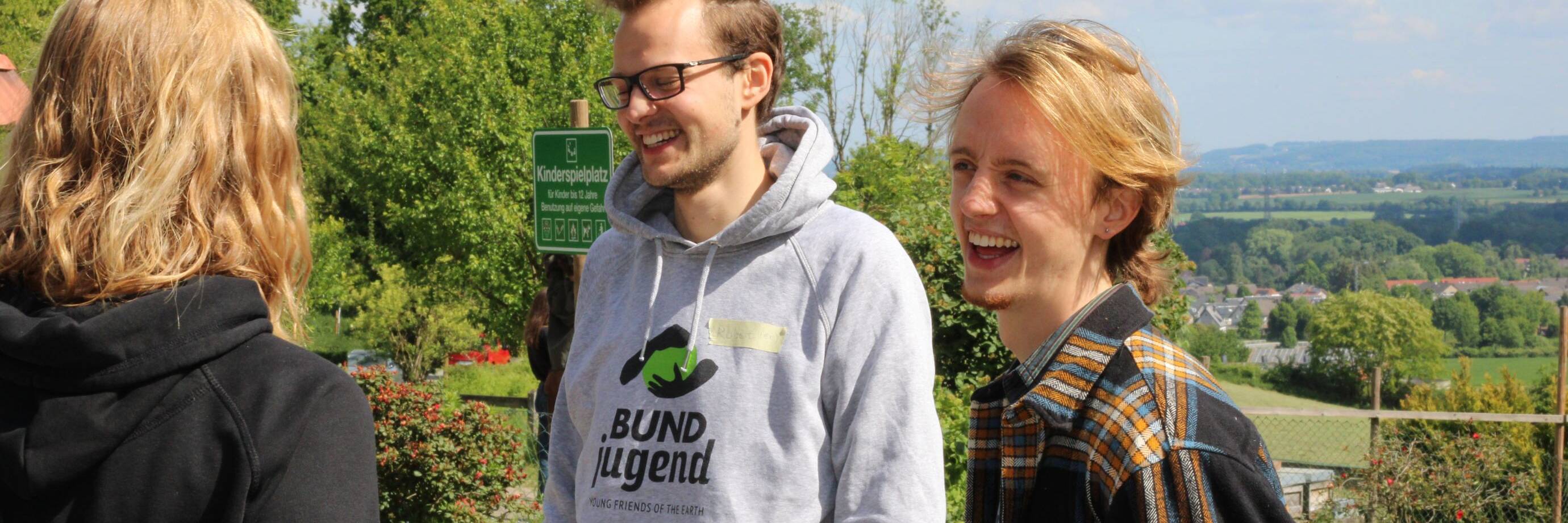 Lachende Personen im Grünen bei Sonnenschein