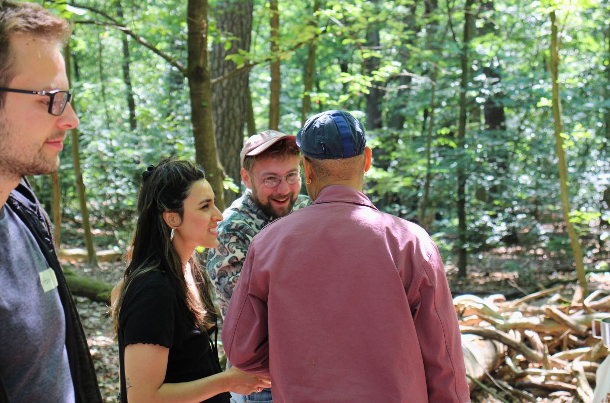 Gruppe von Menschen im Wald im Gespräch.