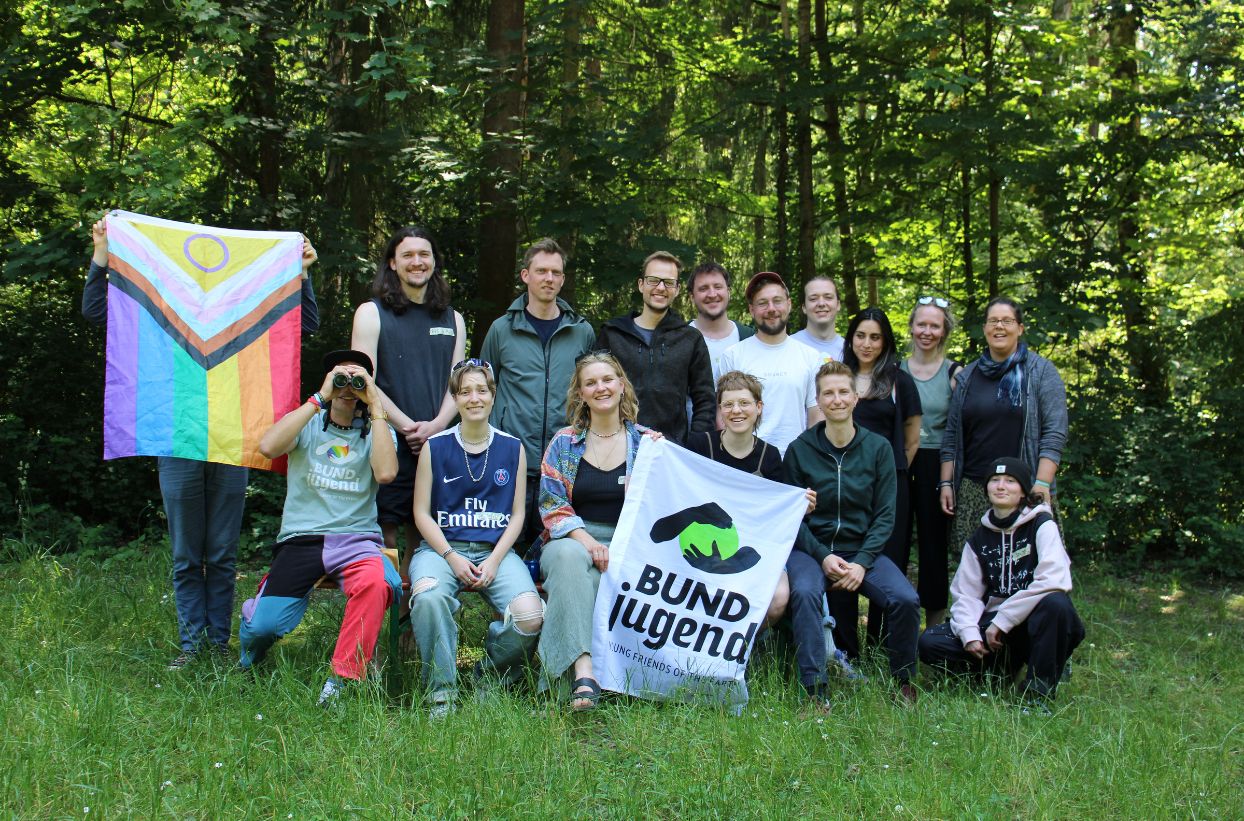 Gruppe im Freien mit bunten und BUND Jugend Fahnen.