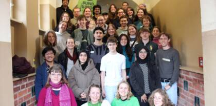 Gruppe von Menschen auf einer Treppe, BUNDjugend Schild.