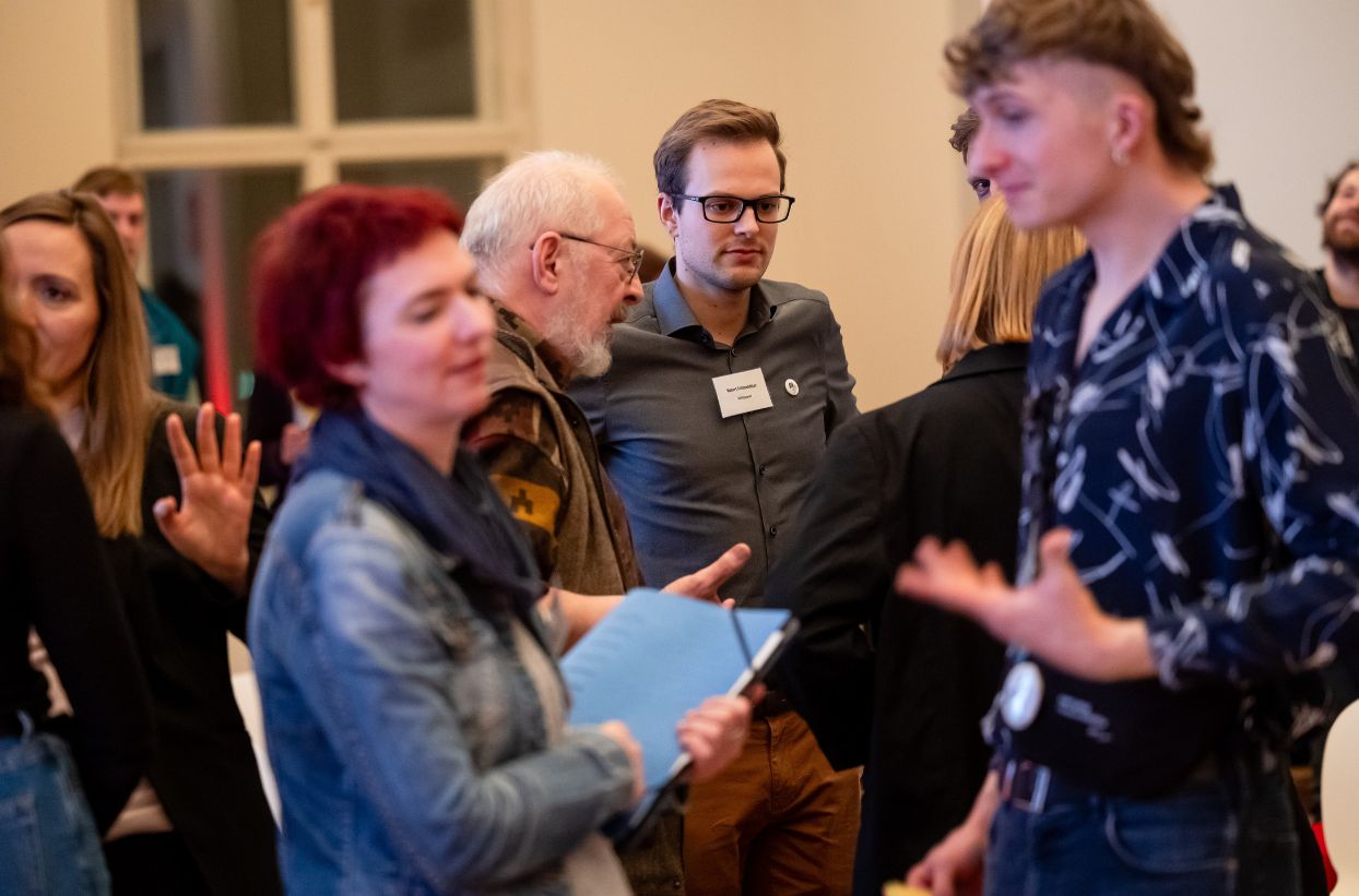 Personen beim Gespräch in einem Raum