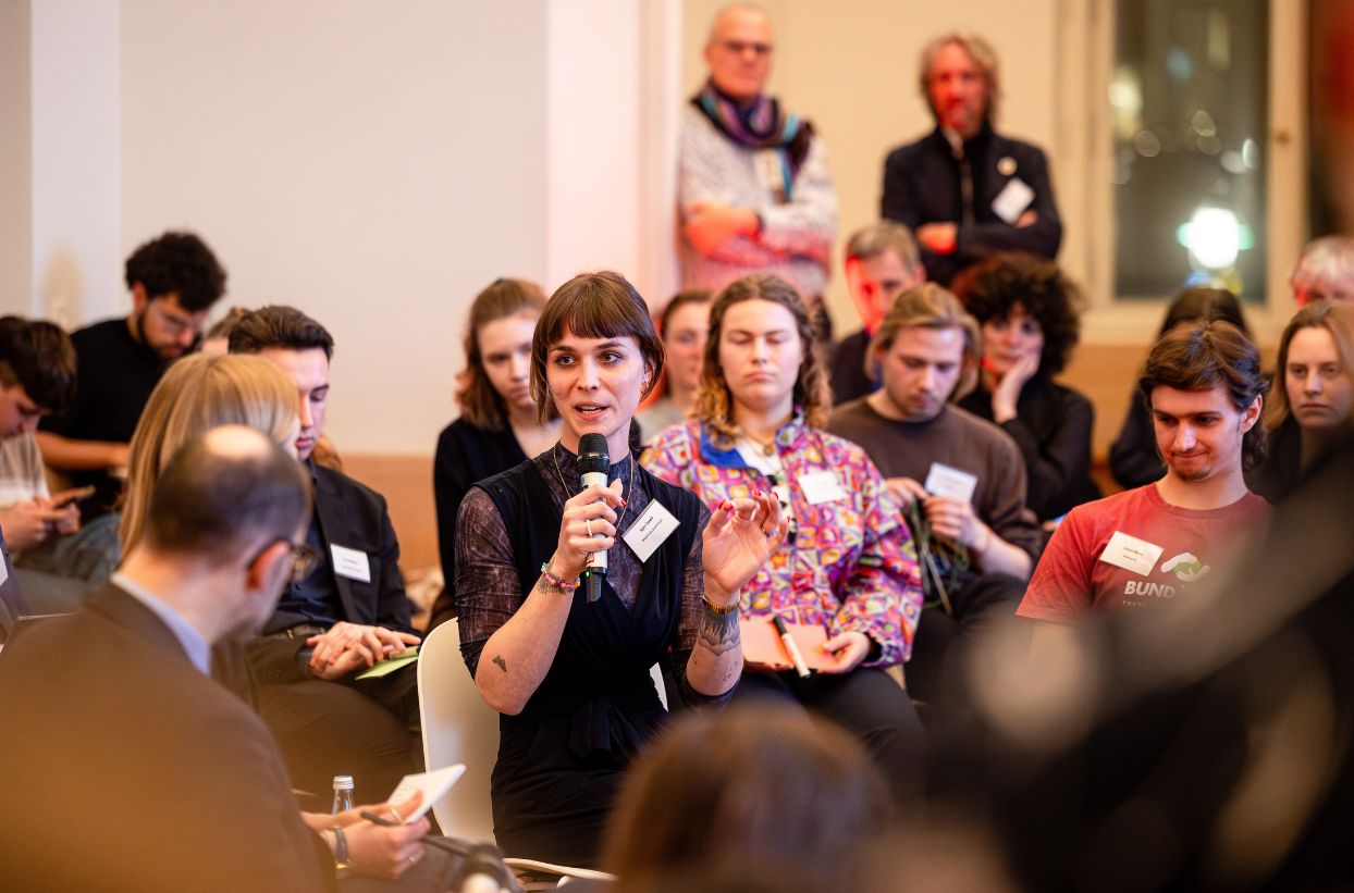 Person hält Vortrag in einer Gruppe